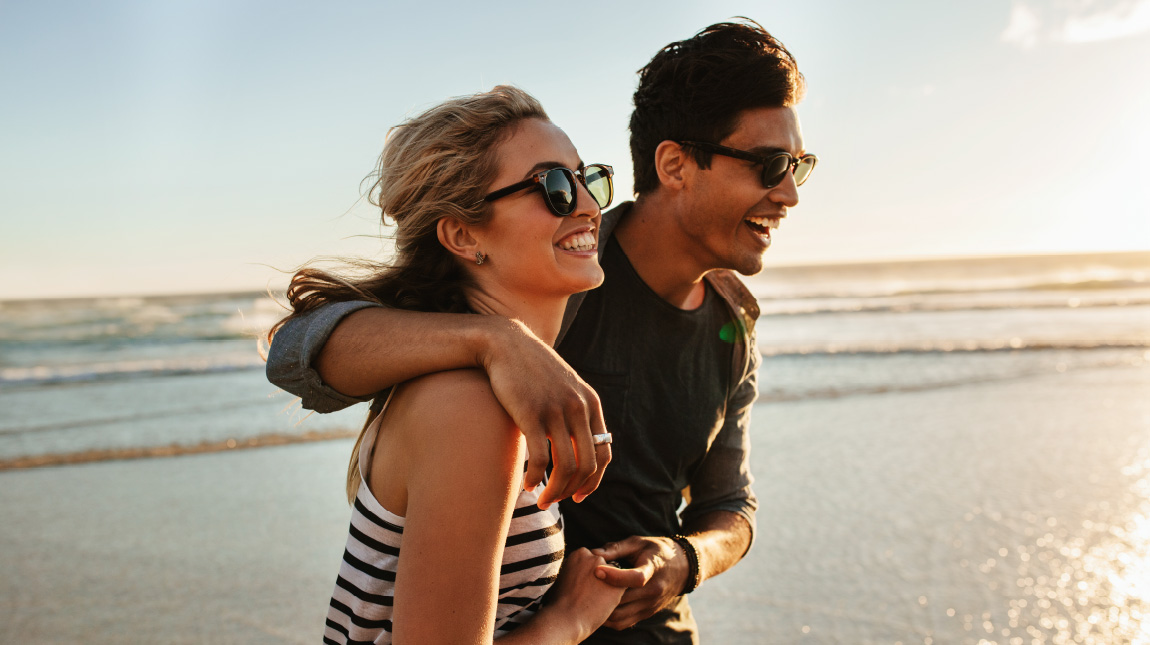 Perspectiva de casal na praia sorrindo